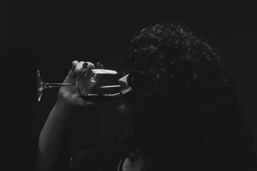 Persona brindando con una copa de vino